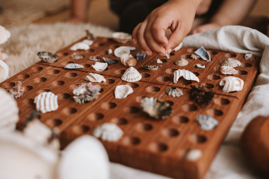 Using sea treasures found while beach combing to count on a 100s board educational play with nature items